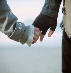 two people holding hands while standing next to each other