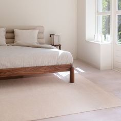 a bed sitting in the middle of a bedroom next to a window