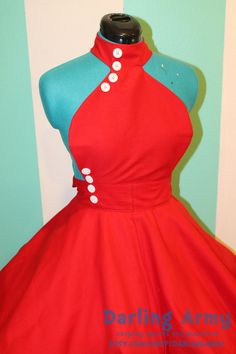 a red and blue dress with white buttons on the collar, sitting on a mannequin