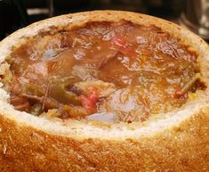 a close up of a soup in a bread bowl on top of a stovetop