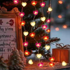 a christmas tree decorated with lights next to a sign