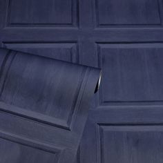 a close up of a blue garage door with a roll of paper in front of it