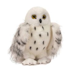 a white and black owl with yellow eyes sitting on its hind legs in front of a white background