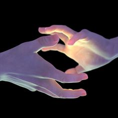 two hands reaching towards each other in the dark