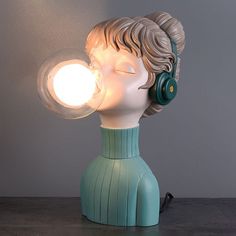 a light that is on top of a table next to a head with earphones