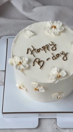 a birthday cake with white frosting and flowers