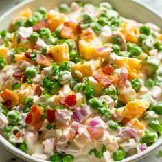 a white bowl filled with peas and fruit salad