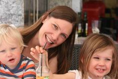 a woman and two children sitting at a table