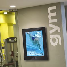 an advertisement on the wall for a gym with a swimming pool in front of it