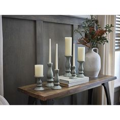 a table topped with candles next to a vase filled with flowers