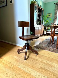 a wooden desk chair sitting on top of a hard wood floor