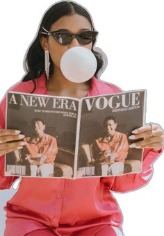 a woman in pink is blowing a bubble while holding a newspaper and chewing on her nose