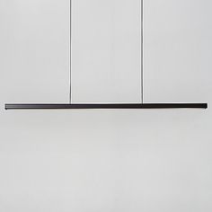 three lights hanging from the ceiling in a room with white walls and black flooring