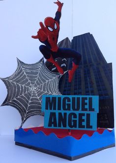 a spider - man statue on top of a sign that says miguel angel