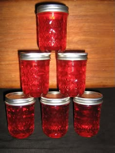 six red glass jars are stacked on top of each other