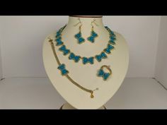 a necklace and earring set with blue beads on a white mannequin stand