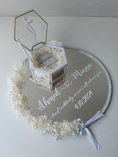 a wedding cake on a silver platter with white flowers and ribbon around the edge