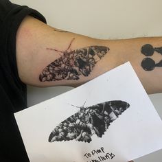 a butterfly tattoo on the left arm and an inked photo of people in sunglasses