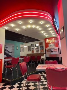 the interior of a diner with checkered flooring and red neon lights on the ceiling