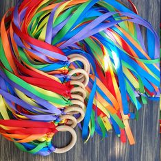 a bunch of colorful streamers and scissors on a wooden table with one pair of scissors in the middle