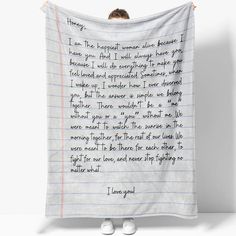 a person standing in front of a white towel with writing on it