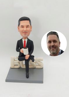 a bobble head sitting on top of a desk next to a photo of a man