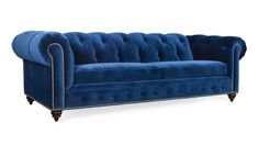 a blue velvet couch with wooden legs and studded trimmings on the arms