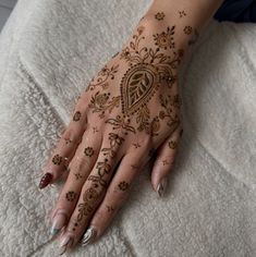 a woman's hand with henna tattoos on it