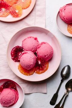 three plates with pink ice cream and orange slices