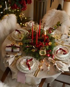 a christmas table setting with candles and plates