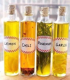 three bottles of lemon, rosemary and rosemary seed oil on a wooden table with a window in the background