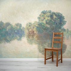 a wooden chair sitting in front of a wall with a painting on it's side