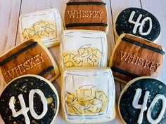 decorated cookies with whiskey on them sitting on a wooden table next to the number forty