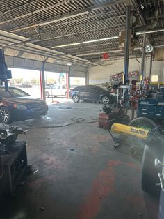 the garage is full of cars and other items for repair, including equipment that are being worked on