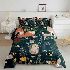 a bed covered in a green comforter with animals and flowers on the coverlet