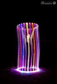 a man standing in front of a colorful light display