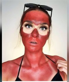 a woman with red face paint and sunglasses on her head