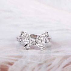 a white gold bow ring with diamonds on it