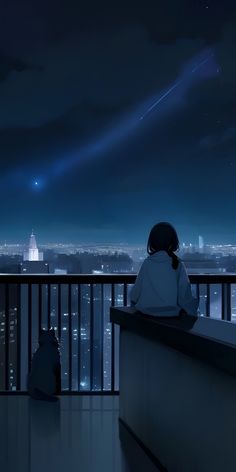 two people sitting on a balcony looking at the night sky