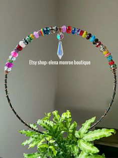 a potted plant sitting on top of a table next to a glass vase filled with beads