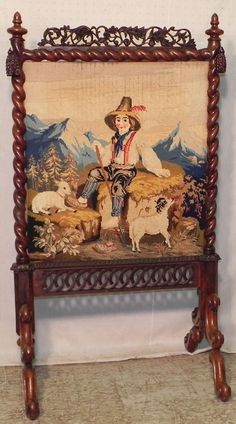 an old wooden chair with a painting on it's back and two sheep standing in front of it