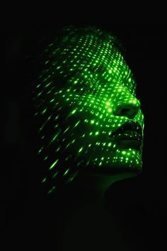 a woman's face is lit up with green lights