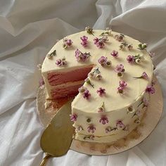 a cake with white frosting and pink flowers on it