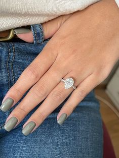 a woman's hand wearing a ring with a diamond in the middle and on her left side