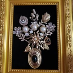 there is a gold framed painting with flowers and pearls on the bottom, along with other decorative items