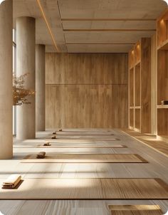 an empty room with rows of wooden shelves on the wall, and several books lined up in rows