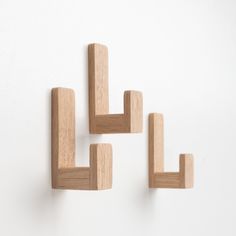 three pieces of wood are arranged on the wall