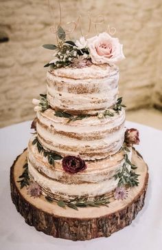 a wedding cake sitting on top of a wooden slice