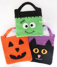 three crocheted halloween bags with faces on them