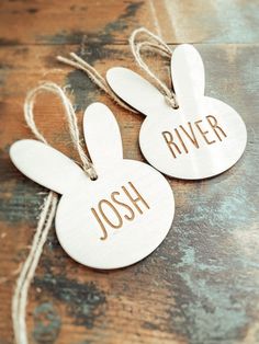 two wooden tags with the words'river'and'rabbit'hanging from twine